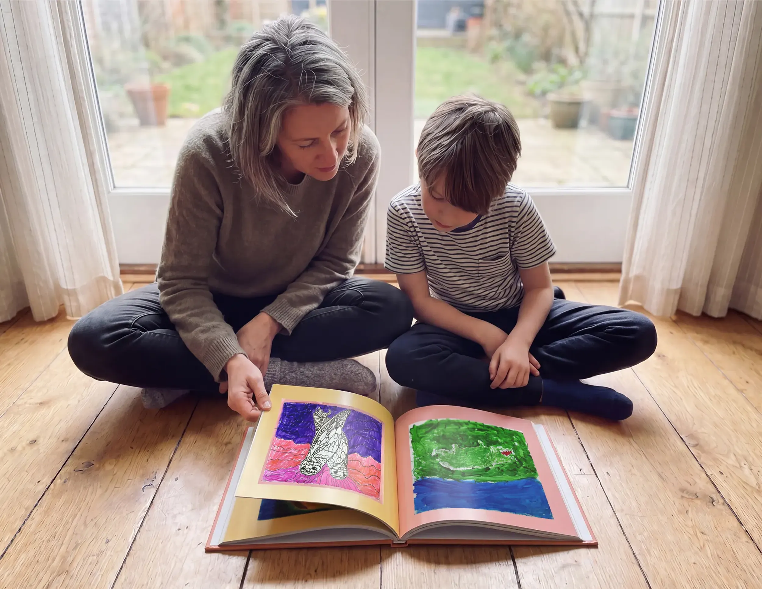Mom and son enjoying their Scribble Art book filled with artwork